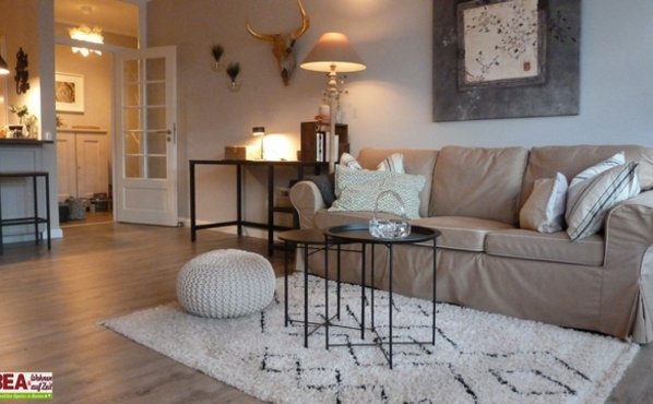Couchbereich mit Teppich, Bild an der Wand und Stehlampe