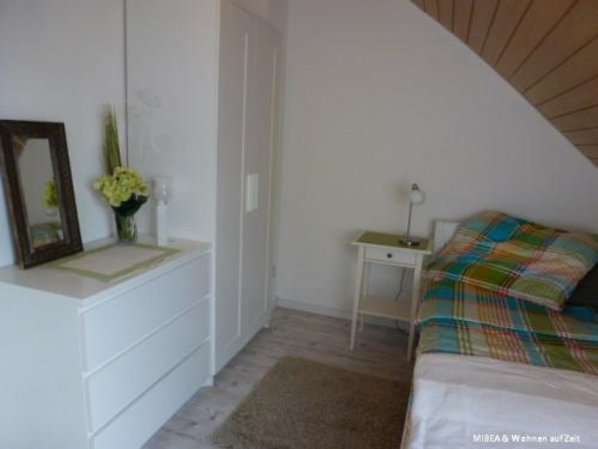 Das Bett mit Kleiderschrank im Bild links und Kommode