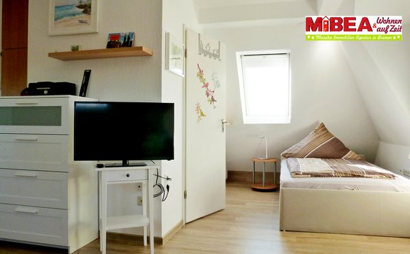 Links im Bild neben dem Bett geht es in das wirklich schöne, helle Badezimmer mit Dusche.
Die Kommode bietet Platz für Ihre Anziehsachen.